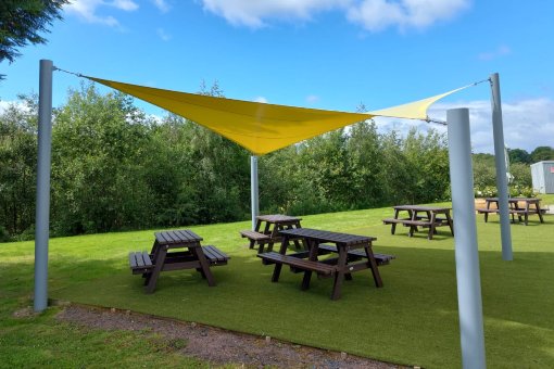 Shade Sail covering picnic tables.